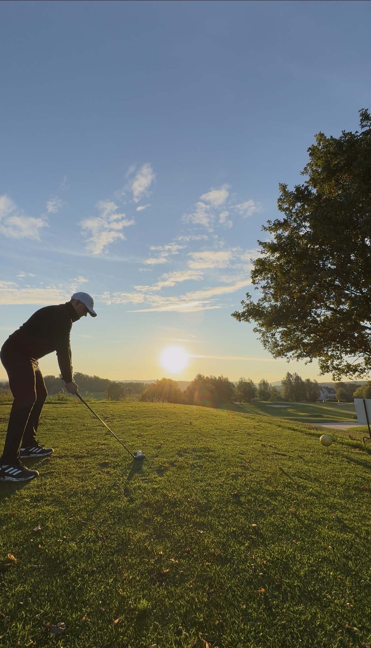 Alexander Maximilian Zwiehoff beim Abschlag im Abendlicht auf dem Golfplatz